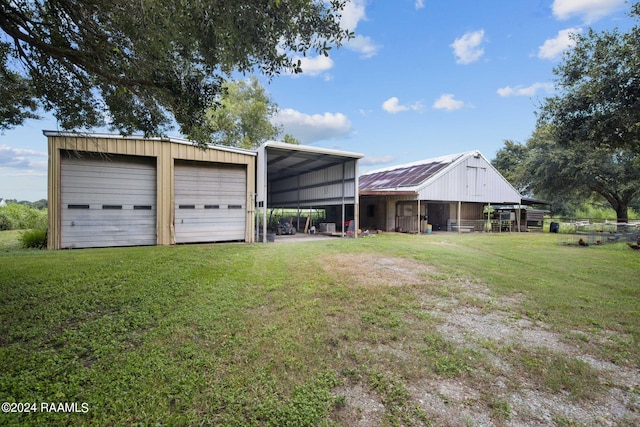 view of front of house with a garage, a front lawn, and an outbuilding