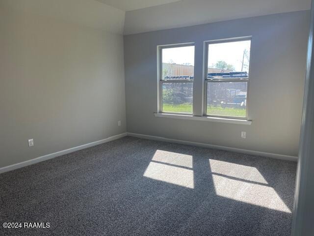 spare room with baseboards and carpet