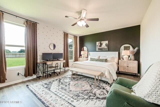 bedroom featuring multiple windows, hardwood / wood-style floors, and ceiling fan