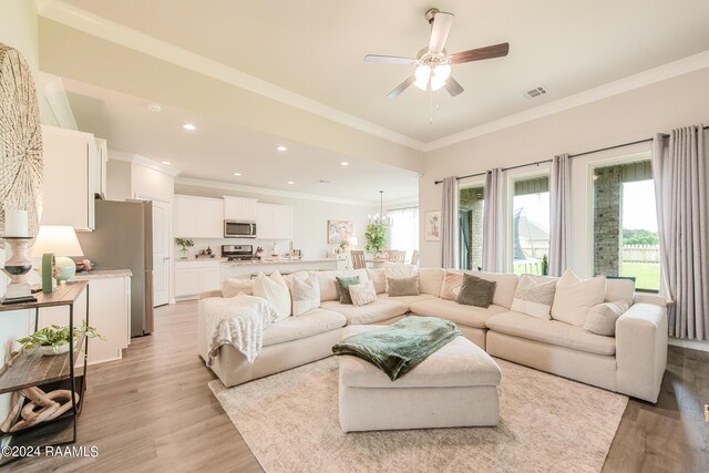 living room featuring ceiling fan, light hardwood / wood-style floors, and crown molding