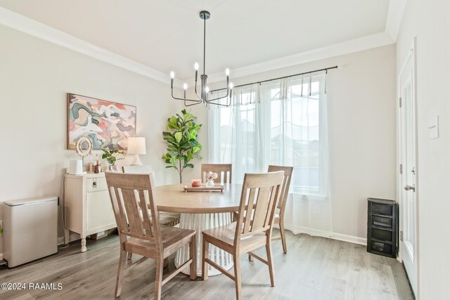 dining space with an inviting chandelier, light hardwood / wood-style floors, heating unit, and ornamental molding