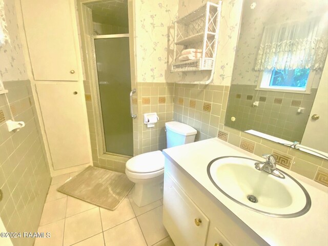 bathroom featuring tile walls, vanity, walk in shower, toilet, and tile patterned floors