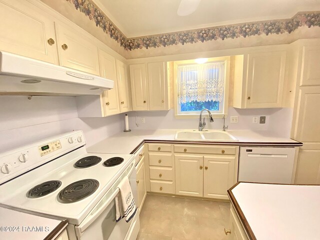 kitchen with white appliances, white cabinetry, sink, and light tile patterned floors