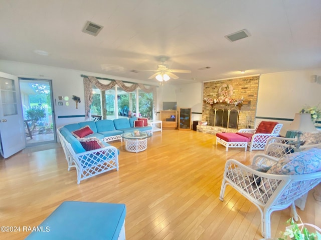 living room with ceiling fan, a fireplace, and hardwood / wood-style floors