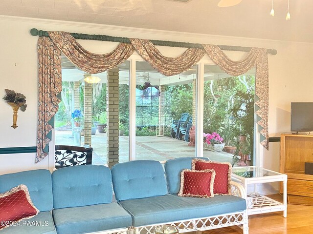 living room featuring hardwood / wood-style flooring, a healthy amount of sunlight, and crown molding