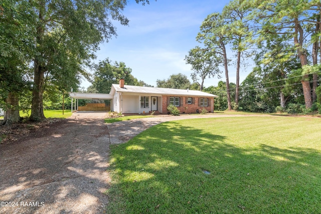 ranch-style home featuring a front lawn, a carport, and covered porch