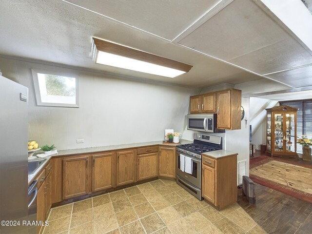 kitchen featuring appliances with stainless steel finishes, sink, and a textured ceiling