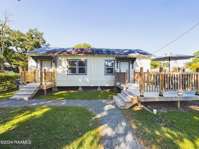 view of front of home featuring a deck and a front lawn