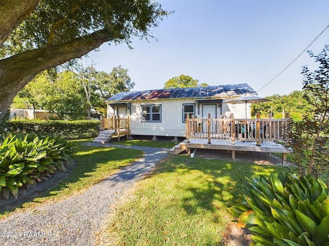 back of property with a wooden deck and a lawn