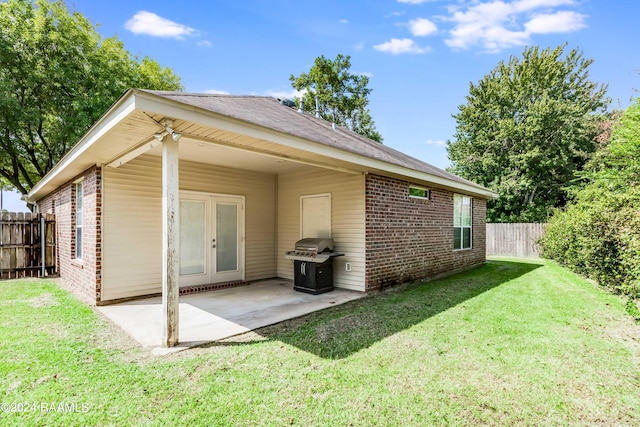 rear view of house featuring a patio area and a yard