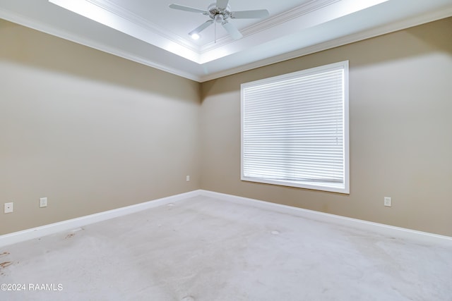 carpeted empty room featuring crown molding, a tray ceiling, and ceiling fan