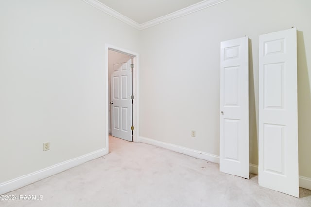 unfurnished bedroom with ornamental molding and light colored carpet