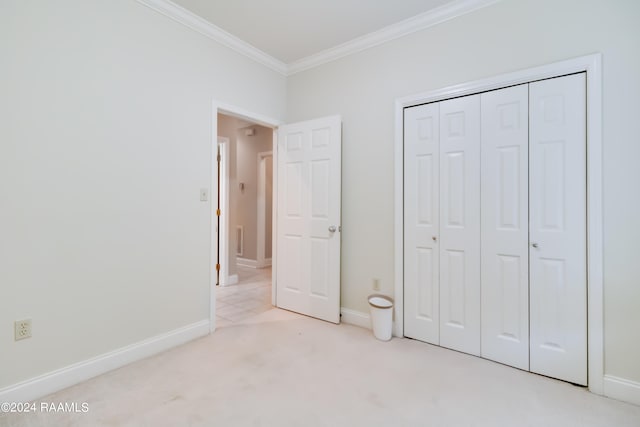 unfurnished bedroom featuring a closet, light colored carpet, and crown molding