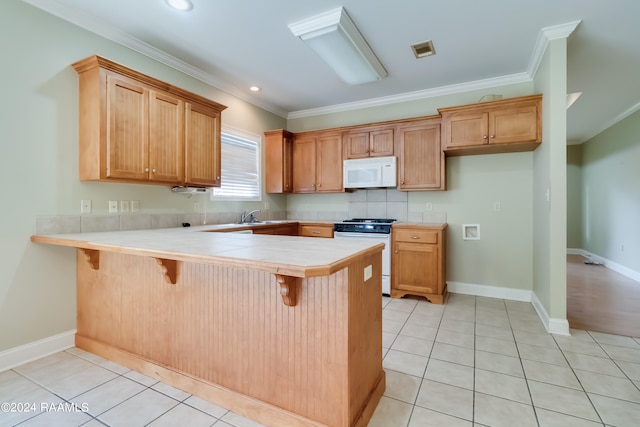 kitchen featuring ornamental molding, white appliances, kitchen peninsula, and a breakfast bar area