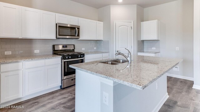 kitchen featuring sink, white cabinetry, a kitchen island with sink, and appliances with stainless steel finishes