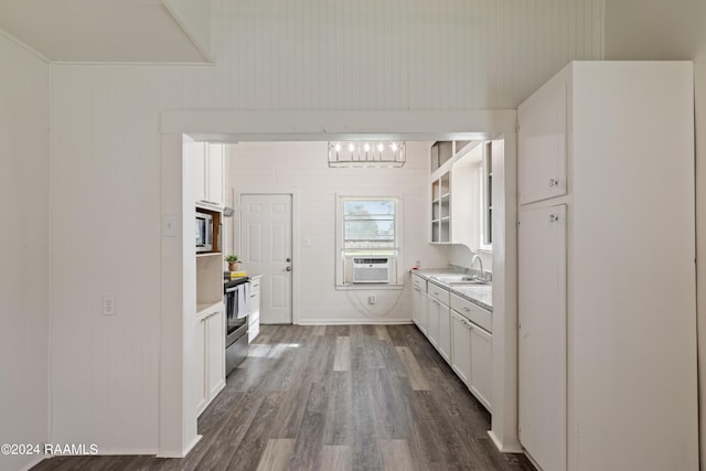 kitchen featuring a sink, stainless steel appliances, white cabinets, light countertops, and dark wood-style flooring