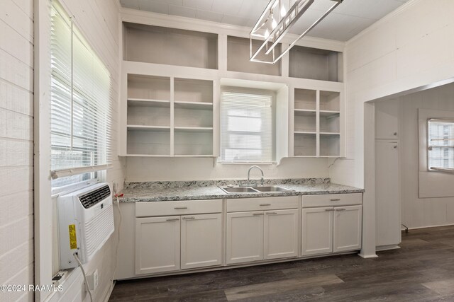 kitchen featuring dark wood-type flooring, a sink, open shelves, light stone counters, and crown molding