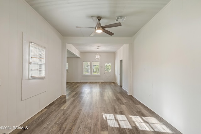 unfurnished room with visible vents, ornamental molding, ceiling fan with notable chandelier, and wood finished floors