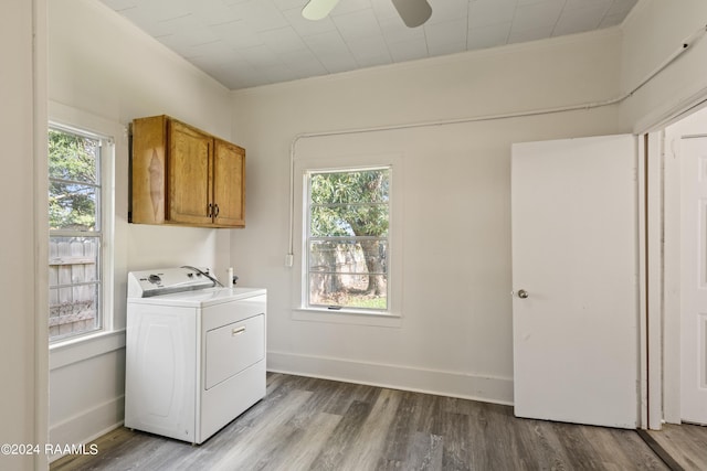 laundry area featuring a wealth of natural light, washer / clothes dryer, cabinet space, and wood finished floors