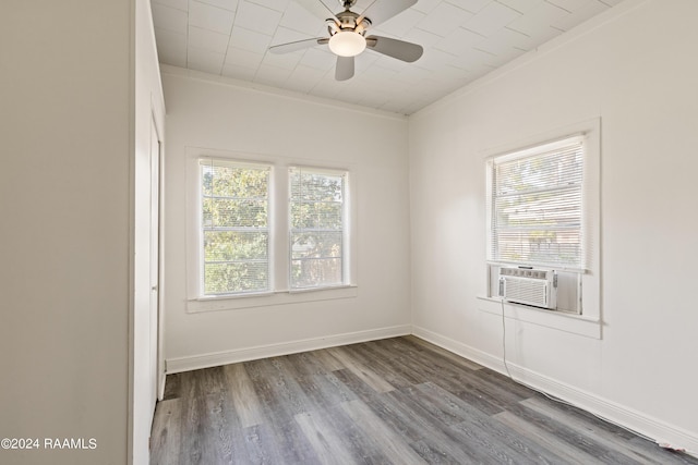 spare room featuring crown molding, baseboards, cooling unit, wood finished floors, and a ceiling fan