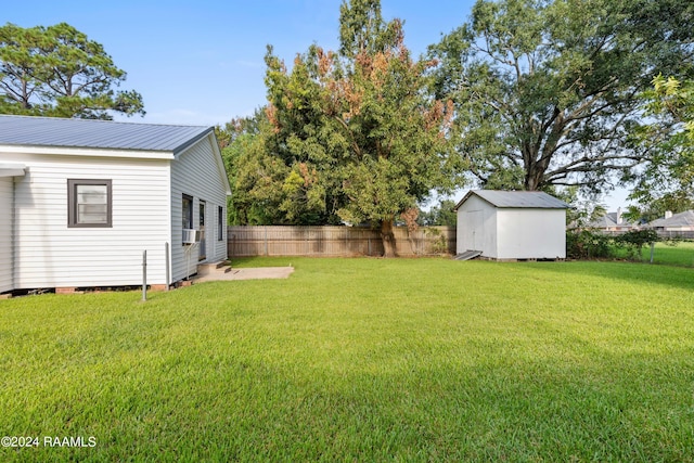 view of yard with an outbuilding, cooling unit, a storage shed, and a fenced backyard