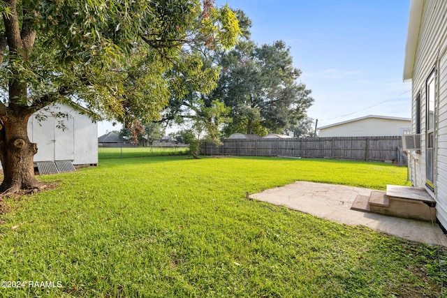 view of yard featuring a patio, an outbuilding, a fenced backyard, and a shed