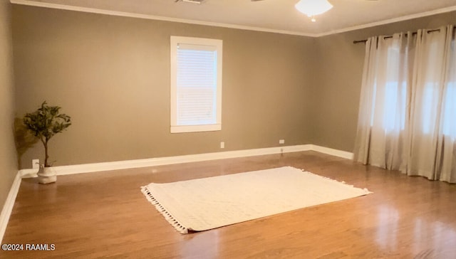 interior space featuring ceiling fan, hardwood / wood-style flooring, and crown molding