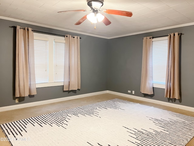 carpeted spare room with ceiling fan and ornamental molding