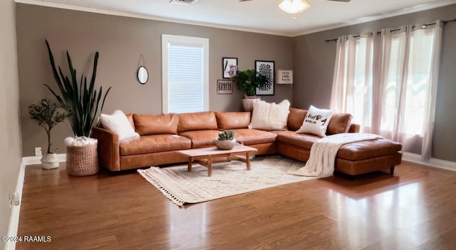 living room with ceiling fan, plenty of natural light, ornamental molding, and wood-type flooring