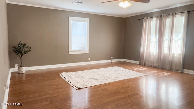 spare room with wood-type flooring, crown molding, and ceiling fan