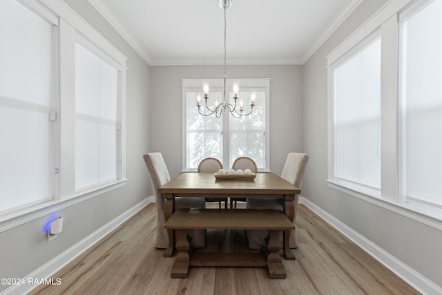 dining area with crown molding, a notable chandelier, and light wood-type flooring