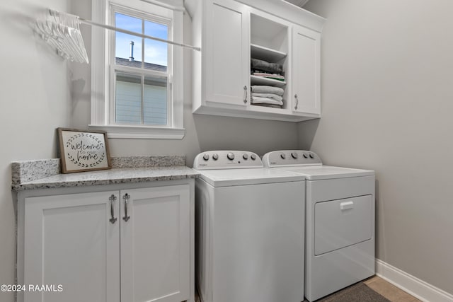 washroom featuring cabinets and washing machine and clothes dryer