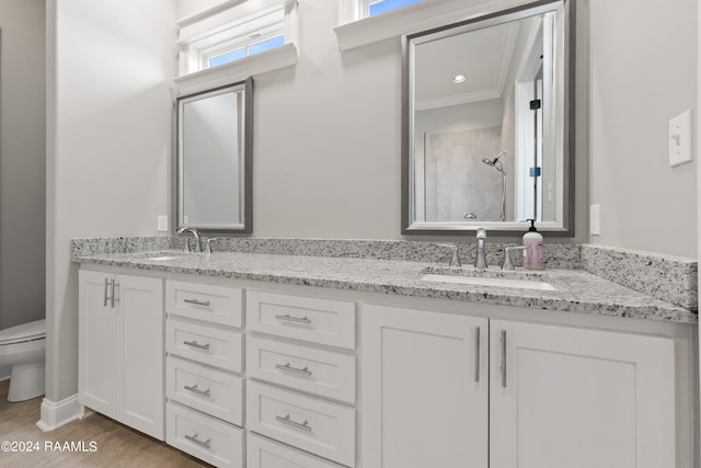 bathroom featuring walk in shower, toilet, ornamental molding, vanity, and hardwood / wood-style floors