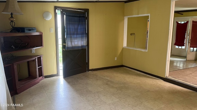 foyer entrance with crown molding and wooden walls