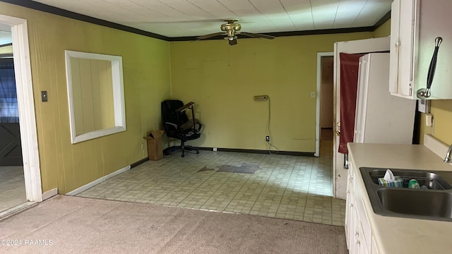 kitchen with light carpet, white cabinetry, sink, ceiling fan, and ornamental molding