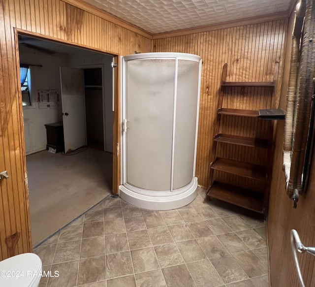 bathroom featuring wood walls, toilet, an enclosed shower, and decorative columns