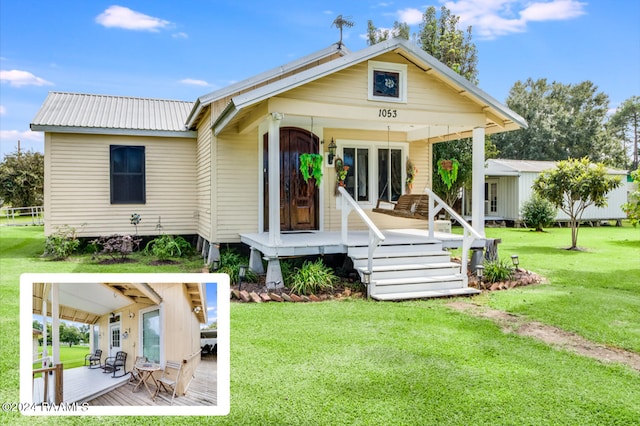 back of house with a porch and a yard