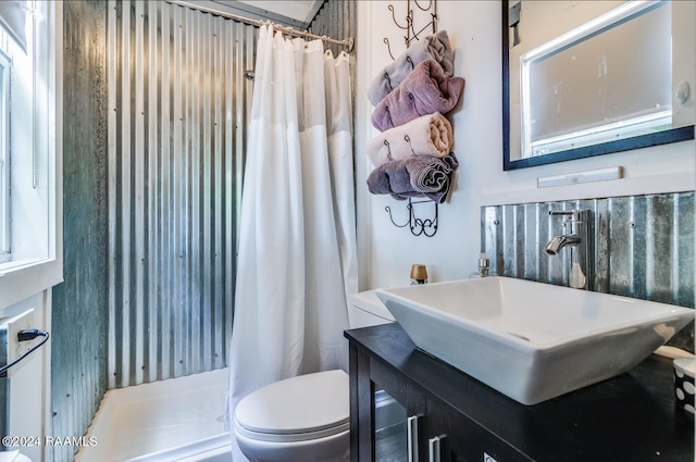 bathroom featuring vanity, toilet, a wealth of natural light, and curtained shower