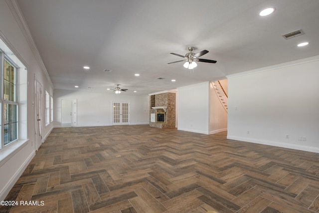 unfurnished living room featuring a large fireplace, ceiling fan, dark parquet floors, and a healthy amount of sunlight