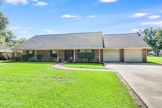 view of front of house with a garage, brick siding, driveway, roof with shingles, and a front lawn