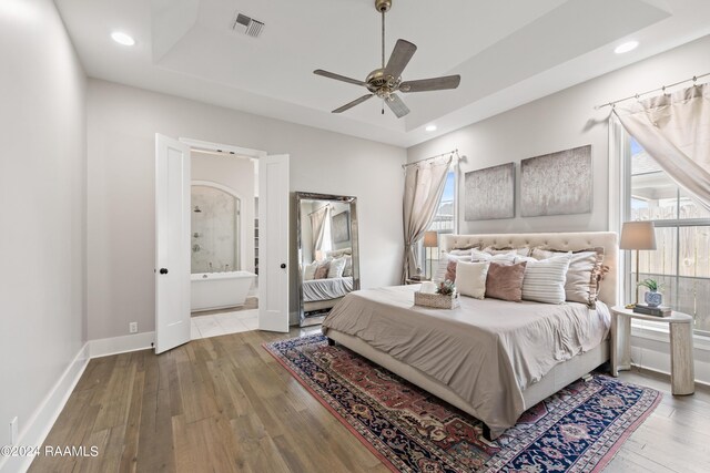 bedroom featuring ceiling fan, connected bathroom, and light hardwood / wood-style floors