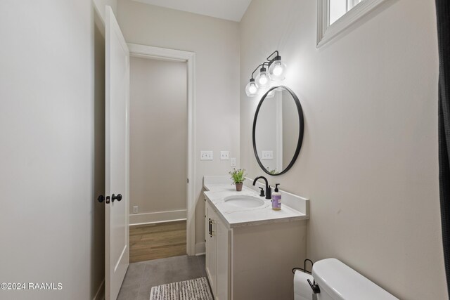 bathroom featuring hardwood / wood-style flooring, vanity, and toilet