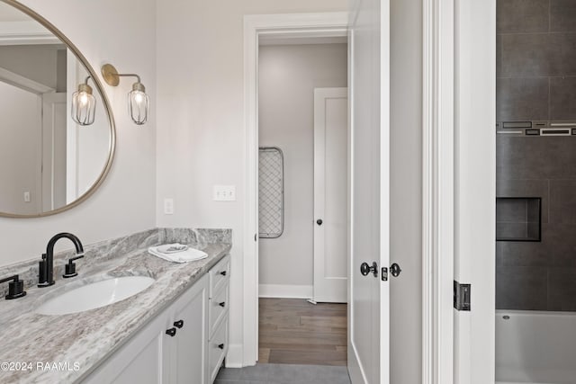 bathroom featuring hardwood / wood-style floors, vanity, and a bathing tub