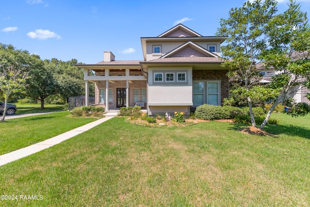 view of front of home featuring covered porch and a front yard