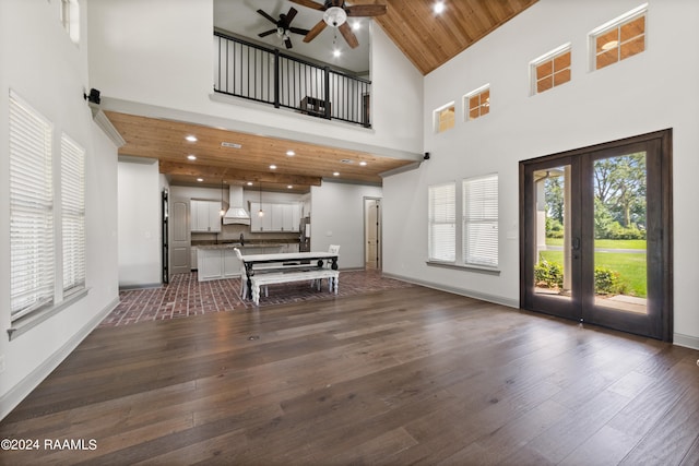 unfurnished living room with high vaulted ceiling, ceiling fan, wood ceiling, and dark hardwood / wood-style floors