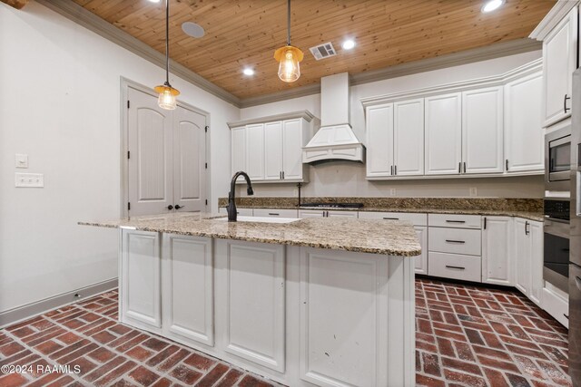 kitchen featuring a center island with sink, custom exhaust hood, sink, and wooden ceiling