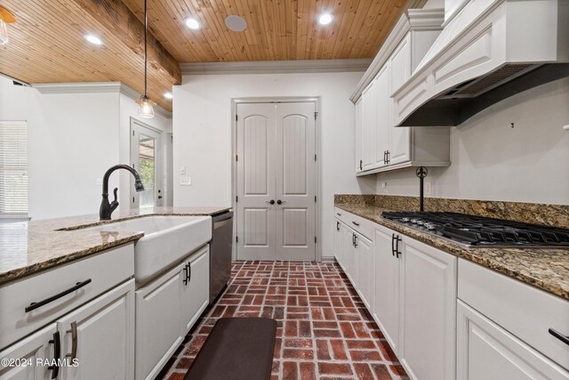 kitchen featuring appliances with stainless steel finishes, pendant lighting, custom exhaust hood, and dark stone counters