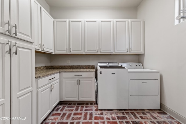 laundry area with washing machine and clothes dryer and cabinets