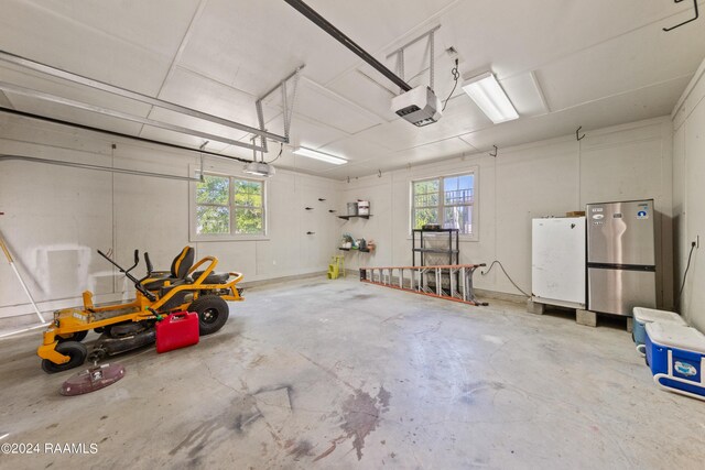 garage featuring stainless steel fridge and a garage door opener