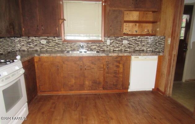 kitchen featuring decorative backsplash, white appliances, wood finished floors, and a sink